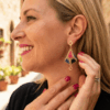 Orecchini pendenti forma a lanterna tridimensionale piena colore oro, nero, blu e rosso indossati da donna con outfit nero