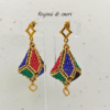 Orecchini pendenti forma a lanterna tridimensionale piena colore oro, nero, blu, verde e rosso su uno sfondo chiaro