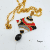 Collana lunga con pendente quadrato geometrico design vintage, tessuto a mano con micro-perline e pietra onice pendente nera, su catena in acciaio dorata.
