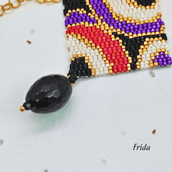 Collana lunga con pendente quadrato geometrico design vintage, tessuto a mano con micro-perline e pietra onice pendente nera, su catena in acciaio dorata.