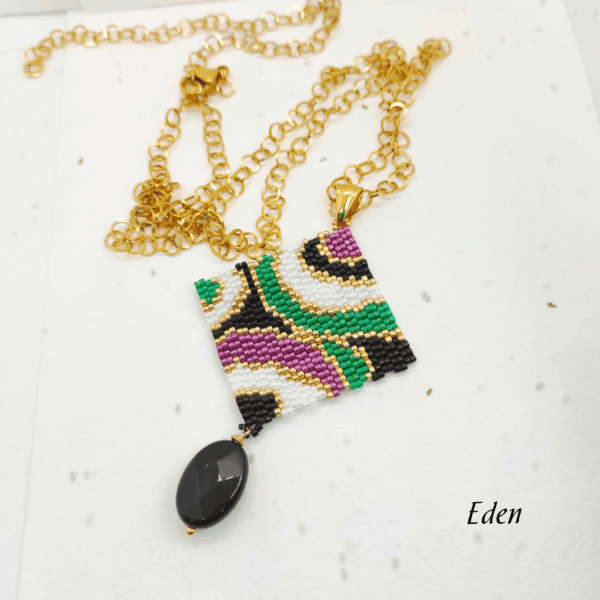 Collana lunga con pendente quadrato geometrico design vintage, tessuto a mano con micro-perline e pietra onice pendente nera, su catena in acciaio dorata.