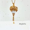 Collana a forma di mongolfiera "Margherita" firmata Vanitage Gioielli, realizzata a mano con perline di vetro sfumate oro, bianco e bronzo, dotata di catena dorata in acciaio e ciondolo a stella in argento 925 su sfondo chiaro