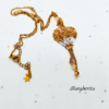 Collana a forma di mongolfiera "Margherita" firmata Vanitage Gioielli, realizzata a mano con perline di vetro sfumate oro, bianco e bronzo, dotata di catena dorata in acciaio e ciondolo a stella in argento 925 su sfondo chiaro