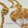 Dettaglio collana a forma di mongolfiera "Margherita" firmata Vanitage Gioielli, realizzata a mano con perline di vetro sfumate oro, bianco e bronzo, dorata di catena dotata in acciaio e ciondolo a stella in argento 925 su sfondo chiaro