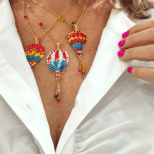 Modella che indossa collane mongolfiera colorate di perline, con una camicia bianca