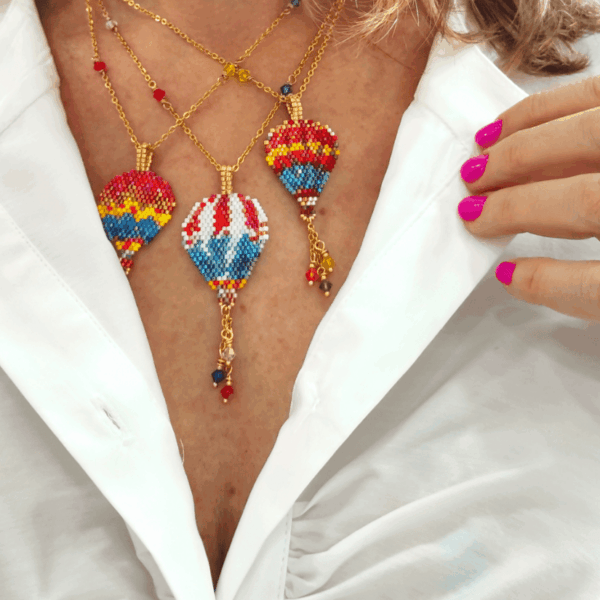 Modella che indossa collane mongolfiera colorate di perline, con una camicia bianca