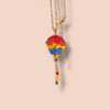 Collana Mongolfiera colorata, realizzata a mano con perline in vetro su sfondo rosa chiaro