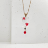 Collana ciondolo corta con pendente asso di cuori e cristalli su sfondo chiaro