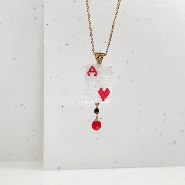 Collana ciondolo corta con pendente asso di cuori e cristalli su sfondo chiaro
