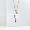 Collana ciondolo corta con pendente asso di fiori e cristalli su sfondo chiaro