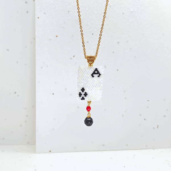Collana ciondolo corta con pendente asso di fiori e cristalli su sfondo chiaro