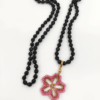 Collana Fiore rosa realizzato a mano con perline in vetro e collana, con cristalli neri di Boemia nodi. Sfondo bianco.