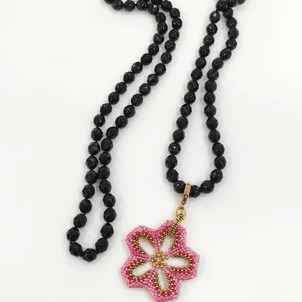 Collana Fiore rosa realizzato a mano con perline in vetro e collana, con cristalli neri di Boemia nodi. Sfondo bianco.