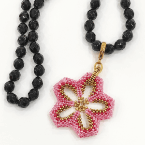 CCollana Fiore rosa realizzato a mano con perline in vetro e collana, con cristalli neri di Boemia nodi. Sfondo bianco.