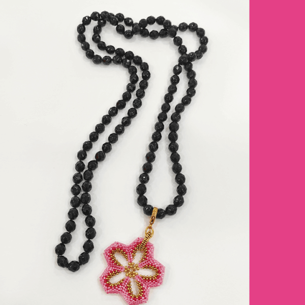 Collana Fiore rosa realizzato a mano con perline in vetro e collana, con cristalli neri di Boemia nodi. Sfondo bianco.