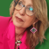 Su uno sfondo verde bosco dettaglio di donna che indossa una giacca fucsia, una collana con ciondolo quadrato e orecchini grandi quadrati