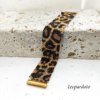 Inquadratura ravvicinata di un bracciale artigianale a fascia larga con motivo maculato leopardato, realizzato con perline Miyuki nere, oro e bronzo metallizzato. Al centro spicca la chiusura a baionetta in metallo dorato lucido.