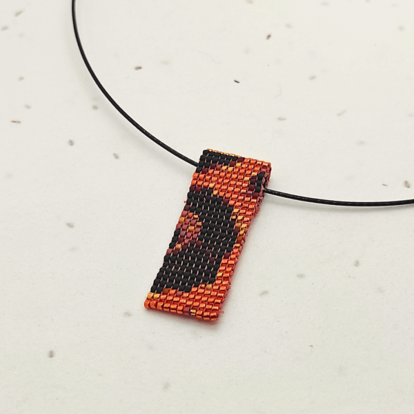 Dettaglio collana corta in stile animalier, su sfondo chiaro.