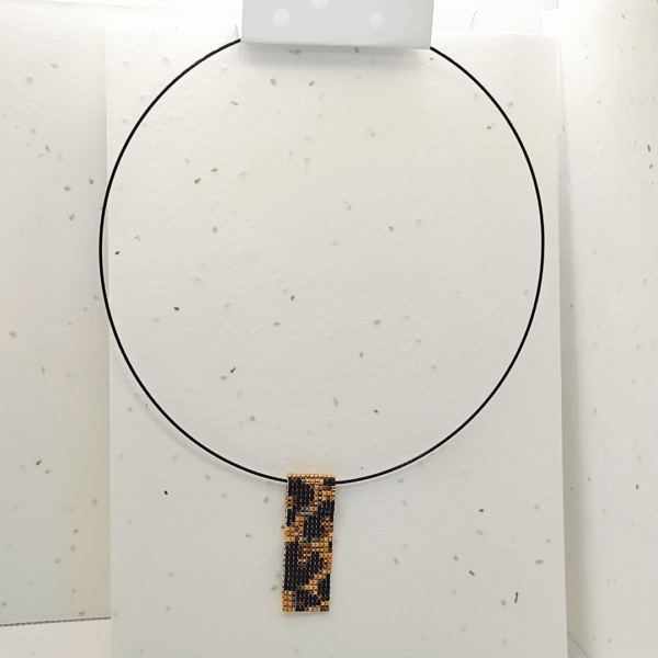 collana corta girocollo in stile animalier ghepardato, su sfondo chiaro