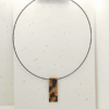 collana corta girocollo in stile animalier leopardato, su sfondo chiaro