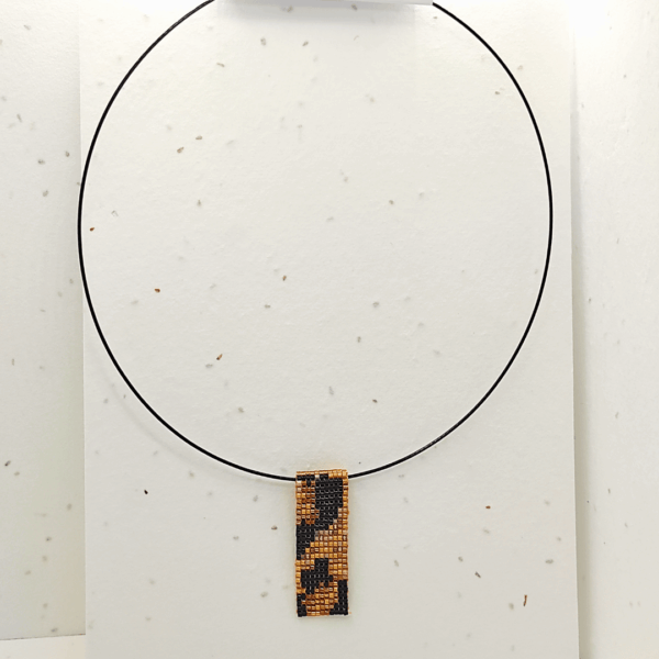 collana corta girocollo in stile animalier leopardato, su sfondo chiaro