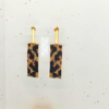 Orecchini pendenti in stile animalier ghepardato, su sfondo chiaro