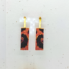 Orecchini pendenti in stile animalier, su sfondo chiaro