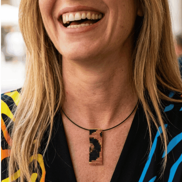 collana corta in stile animalier indossata da donna con i capelli biondi e outfit nero