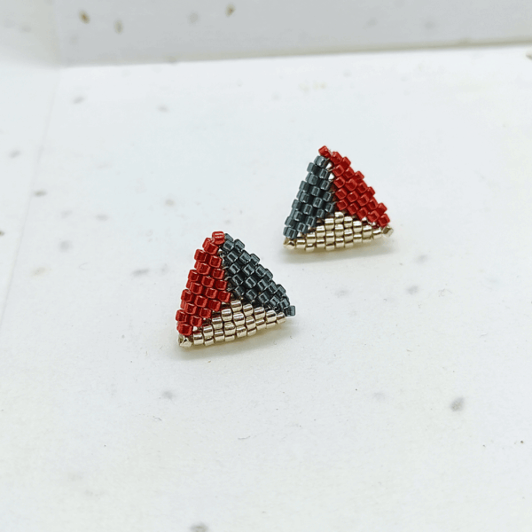 orecchini a lobo a triangolo argentati, colorati su sfondo chiaro