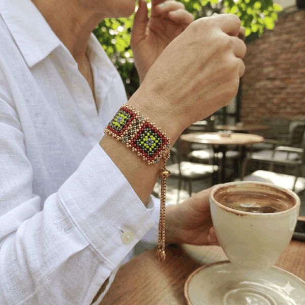 Modella che indossa il bracciale granny modello Soul di perline, con una camicia bianca, mentre beve un caffè