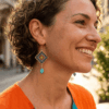 Orecchini di perline pendenti con design Granny indossato da donna con i capelli scuri e abito arancione e turchese