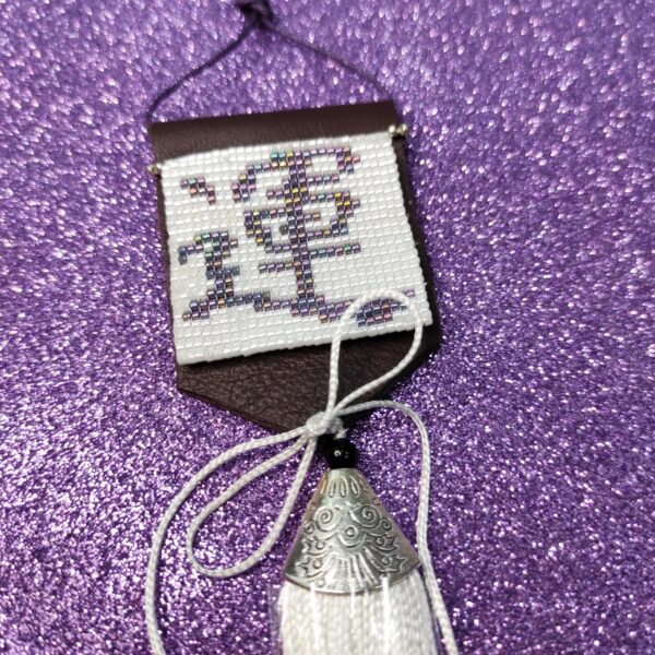 Amuleto Kanji della fortuna, realizzato con perline in vetro e nappa bianca pendente, su sfondo viola