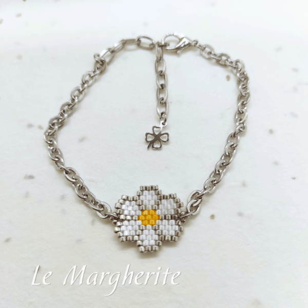 Bracciali margherite di perline fatte a mano con catena in acciaio dorato su sfondo bianco