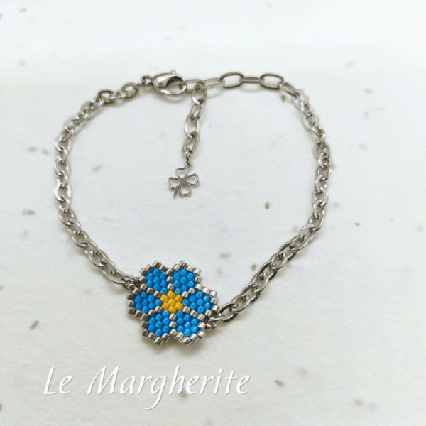 Bracciali margherite di perline fatte a mano con catena in acciaio dorato su sfondo bianco