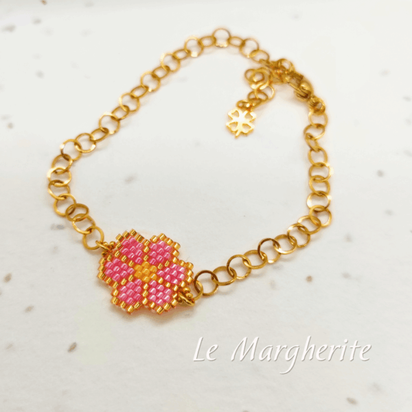 Bracciali margherite di perline fatte a mano con catena in acciaio dorato su sfondo bianco