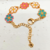 Bracciali margherite di perline fatte a mano con catena in acciaio dorato su sfondo di carta bianca