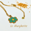Collana ciondolo margherita turchese di perline fatte a mano con catena in acciaio dorato, su sfondo bianco