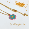 Collana ciondolo margherita turchese e rosa di perline fatte a mano con catena in acciaio dorato, su sfondo bianco
