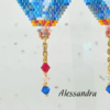 Dettaglio orecchini pendenti a forma di mongolfiera firmati Vanitage Gioielli, realizzati a mano con perline di vetro nei toni del rosso, bianco, azzurro e blu, completati da catenella dorata e cristalli pendenti.