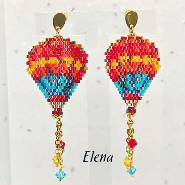 Orecchini pendenti a forma di mongolfiera modello Elena di Vanitage Gioielli, fatti a mano con perline di vetro colorate, completati da cristalli pendenti colorati.