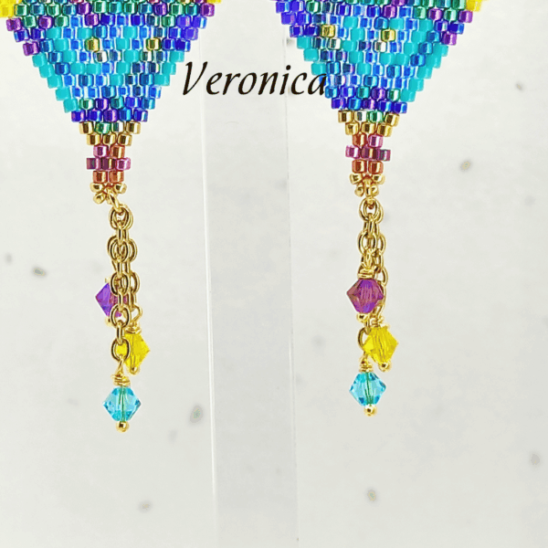 Dettaglio orecchini pendenti a forma di mongolfiera modello Veronica di Vanitage Gioielli, fatti a mano con perline di vetro blu, viola, verdi e gialle, completati da cristalli colorati.