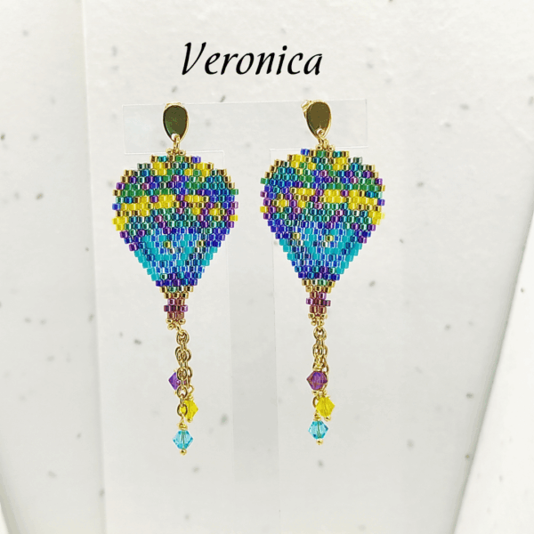 Orecchini pendenti a forma di mongolfiera modello Veronica di Vanitage Gioielli, fatti a mano con perline di vetro blu, viola, verdi e gialle, completati da cristalli colorati.