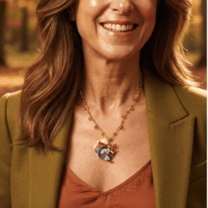 Collana fatta a mano con ciondolo a forma di scoiattolo colorato, realizzata con un mosaico di perline di vetro e abbinata a una catenina dorata con piccoli cristalli arancioni. Indossato