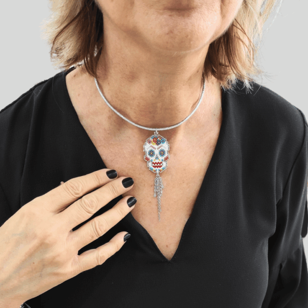 Collana Vanitage con pendente teschio messicano in perline colorate e frange pendenti di catenelle argentate, indossata su cordino rigido argento.