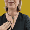 Collana Vanitage con pendente teschio messicano in perline colorate e frange pendenti di catenelle argentate, indossata su cordino rigido nero.